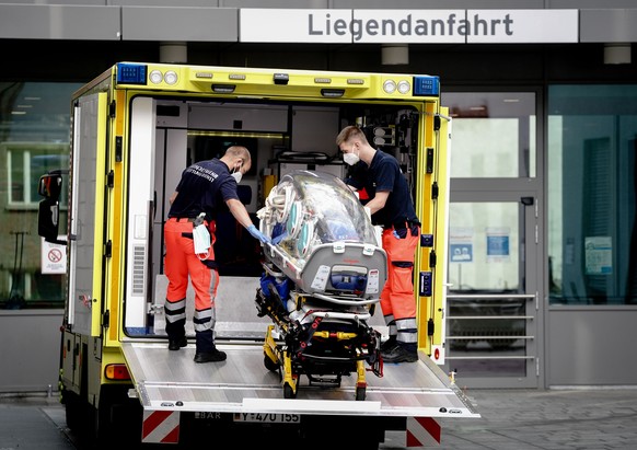 22.08.2020, Berlin: Sanitaeter vom Bundeswehr Rettungsdienst bringen die Spezialtrage, mit der Nawalny in die Charite eingeliefert wurde, zurueck in den Krankenwagen. Der moeglicherweise vergiftete Kr ...