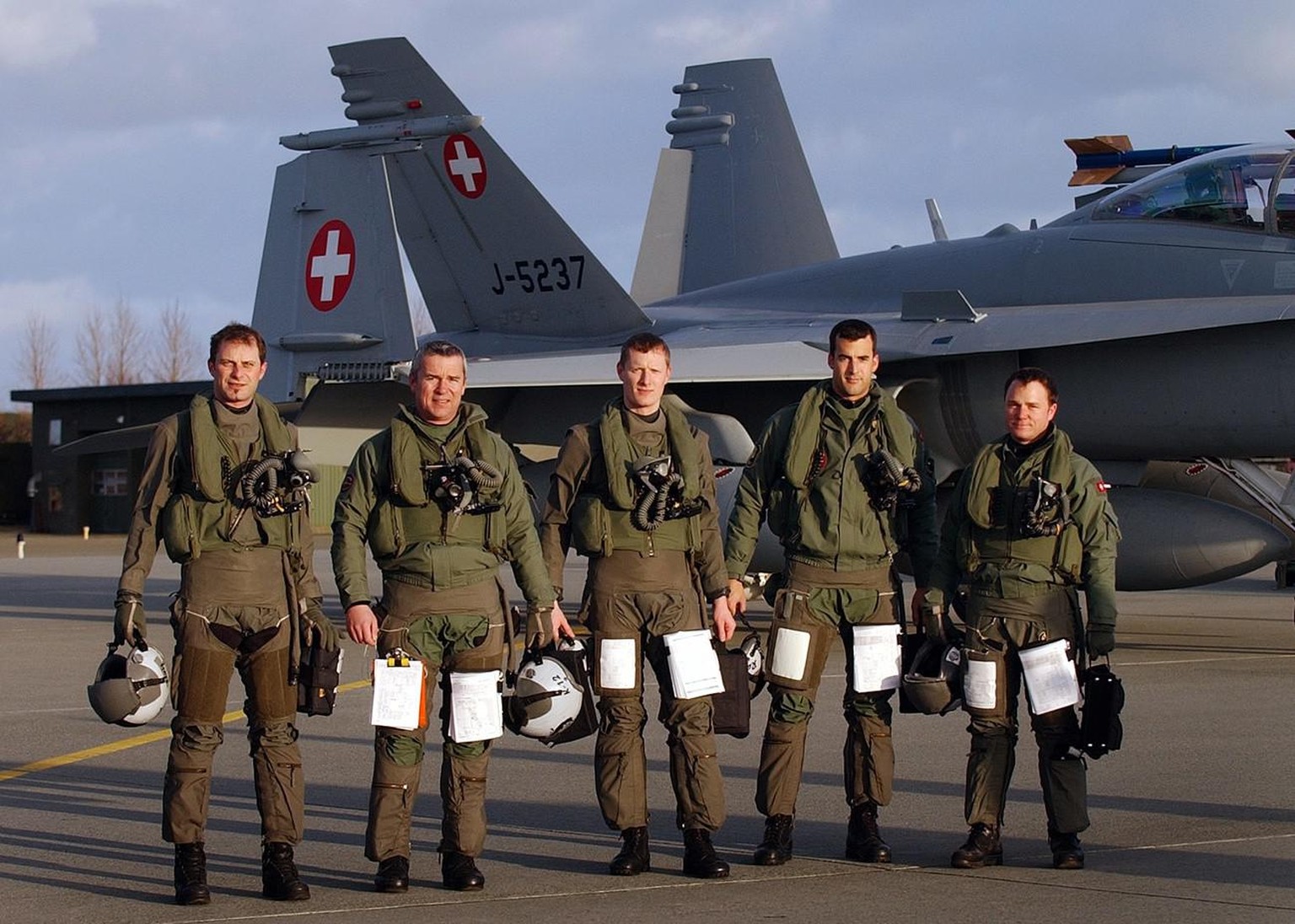 Die Piloten v.l. Mike Reiner, Gerhardt Kraehenbuehl, Jascha Haller, Ralph Iseli und Michael Junker nach geflogenem Einsatz vor einem F/A 18 Kampfjet, aufgenommen am Dienstag, 2. Maerz 2004, anlaesslic ...