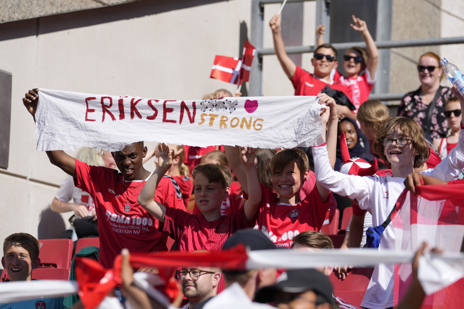 Young Danish fans hold a banner referring to Denmark&#039;s Christian Eriksen before the Euro 2020 soccer championship group B match between Denmark and Belgium at Parken stadium in Copenhagen, Denmar ...