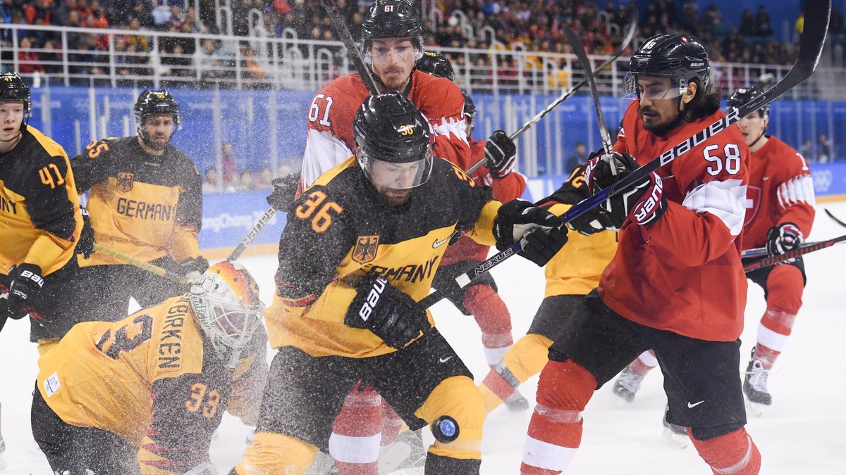 epa06546385 (L-R) Danny aus den Birken, goalkeeper of Germany, Yannic Seidenberg of Germany and Fabrice Herzog and Eric Blum of Switzerland fight for the puck during the Men's Ice Hockey play-off ...