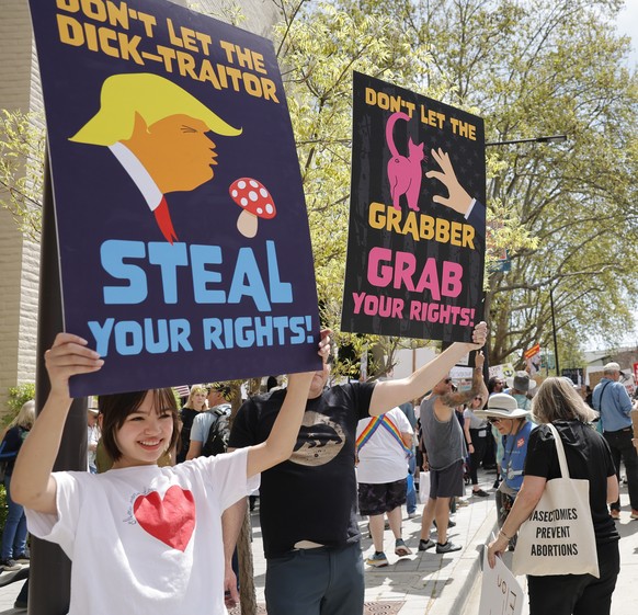 epa12012635 Protesters rally during a nationwide ?Hands Off!? protest against President Trump, his advisor Elon Musk and his policies in front of a Tesla showroom at the Broadway Plaza Mall in Walnut ...