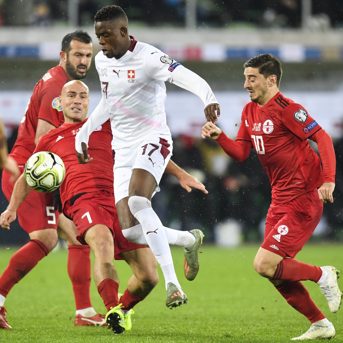 Georgia's Jaba Kankava, left, and Georgia's Jano Ananidze right, fight for the ball with Switzerland's midfielder Denis Zakaria, center, during the UEFA Euro 2020 qualifying Group D soc ...