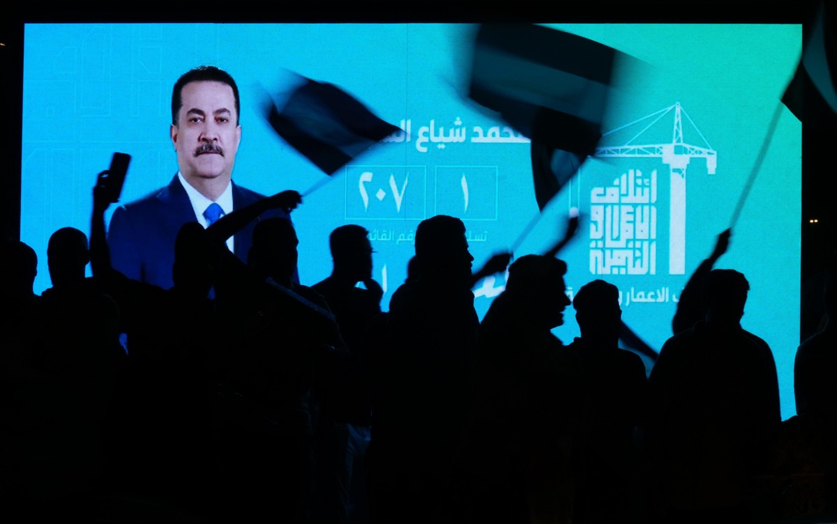 Iraqi Prime Minister Mohammed Shia al-Sudani is displayed on a screen as supporters celebrate following the announcement of the results of the parliamentary elections in Tahrir Square, Baghdad, Iraq,  ...