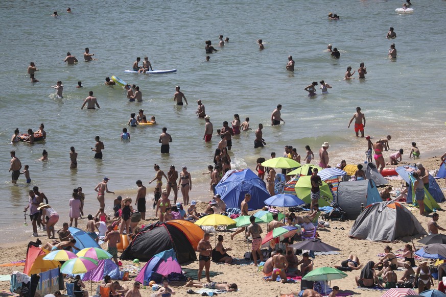 Crowds gather at the water's edge as hot weather draws crowds to the beach in Bournemouth, England, Thursday June 25, 2020. Coronavirus lockdown restrictions are being relaxed but people should s ...