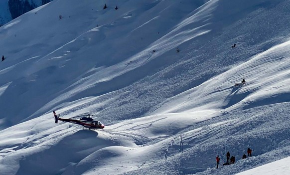 epaselect epa09730184 A police helicopter and emergency teams work at the site of an avalanche in the Spiss municipality, Austria, 04 February 2022 (issued 05 February 2022). The avalanche had occurre ...