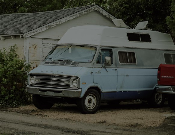 Denver, Colorado/USA - 05.06.2015: Old blue Dodge van and Dodge logo on the back of a red pickup truck next to an old house on the streets of Denver, Colorado.
murder van kidnap van.