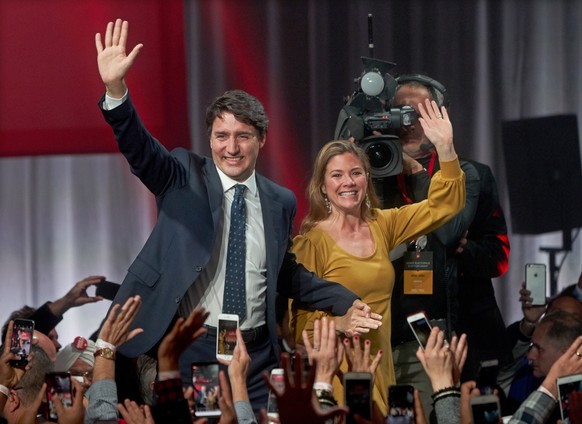 epa07939715 Canadian Prime Minister and Liberal Party leader Justin Trudeau (L) and his wife, Sophie Gregoire Trudeau (R), wave to the crowd after a victory speech in Montreal, Quebec, Canada, 22 Octo ...