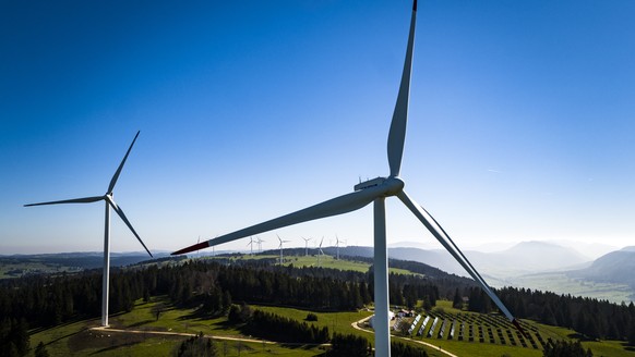 ARCHIVBILD - Nationalrat stimmt am 8. Maerz 2023 fuer Windenergieoffensive - Wind turbines from the JUVENT power plant and solar panels from the solar station of the Mont-Soleil are pictured on the Mo ...