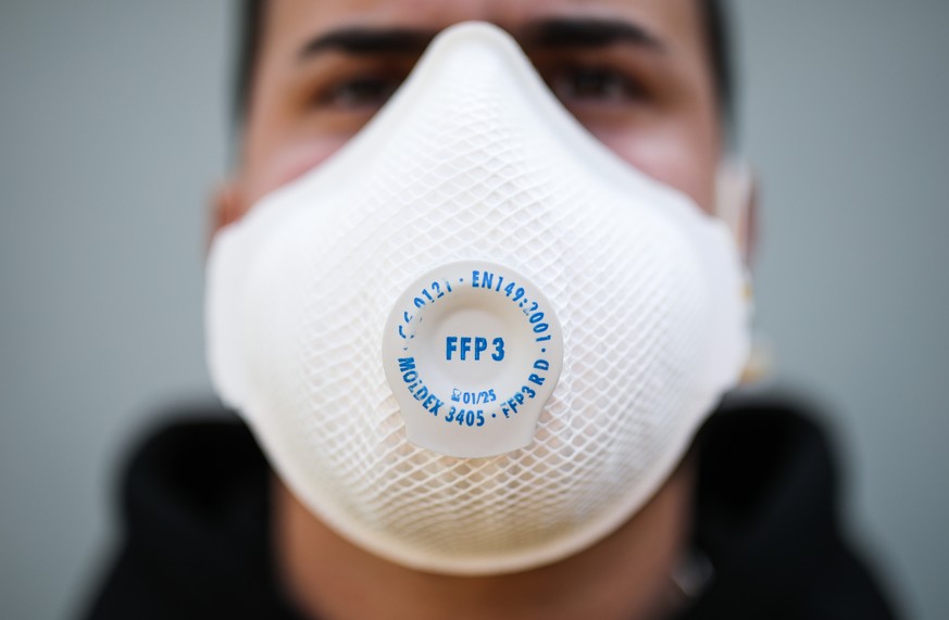 SYMBOLBILD - 15.04.2020, Baden-Württemberg, Stuttgart: Ein junger Mann trägt eine Atemschutzmaske der Kategorie FFP3 (gestellte Aufnahme). (zu dpa: «Autofahrer dürfen Schutzmasken am Steuer tragen») F ...