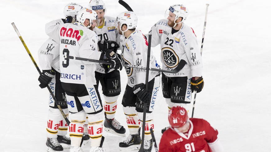 Les joueurs de Lugano celebrent le premier but devant la deception de l&#039;attaquant lausannois Joel Vermin, droite, lors du match du championnat suisse de hockey sur glace de National League entre  ...