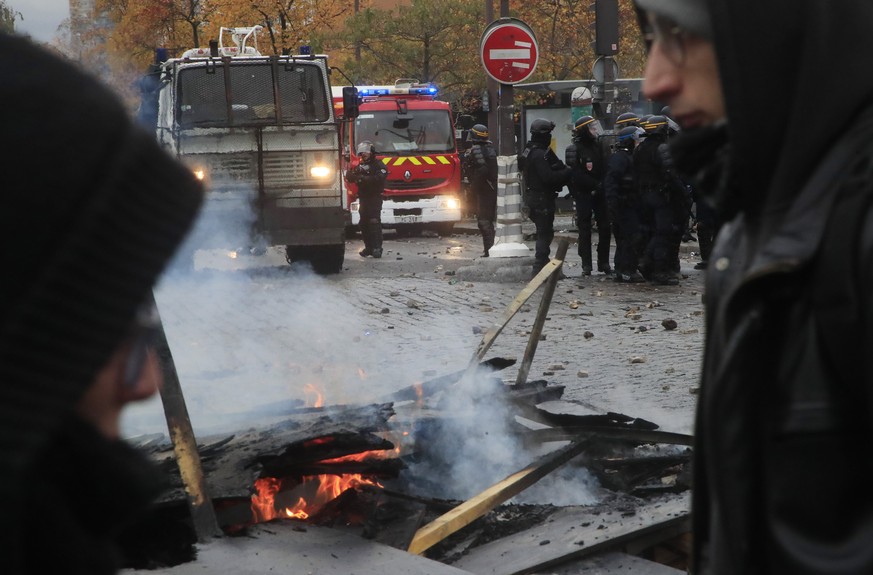 French riot police officers face protesters during a yellow vest demonstration marking it&#039;s first anniversary, in Paris, Saturday, Nov. 16, 2019. Tear gas and water cannon were used Saturday as P ...