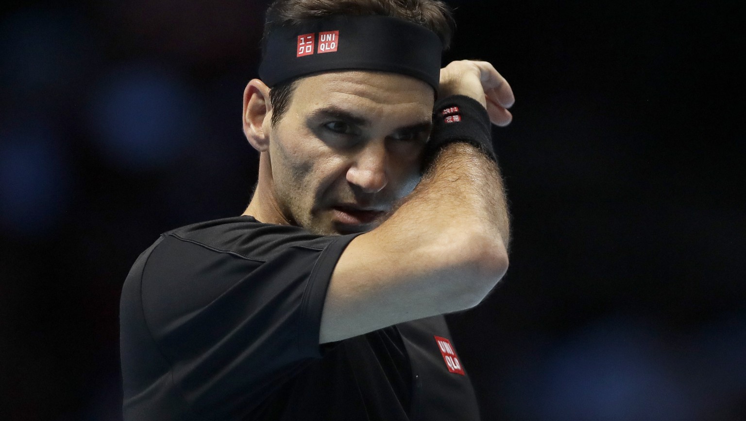 Roger Federer of Switzerland wipes his face after he plays a return to Stefanos Tsitsipas of Greece during their ATP World Tour Finals semifinal tennis match at the O2 Arena in London, Saturday, Nov.  ...