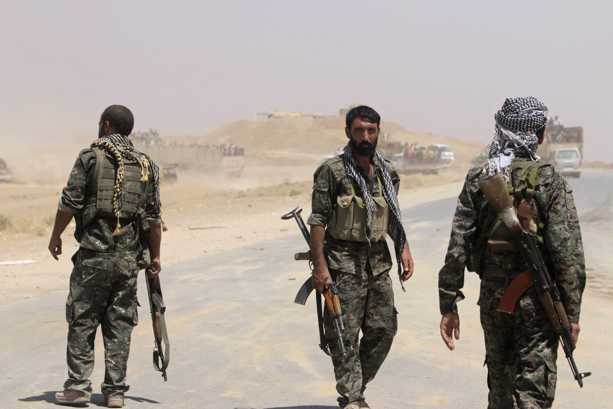 Members of the Kurdish People's Protection Units (YPG) facilitate displaced people from the minority Yazidi sect, who are fleeing violence from forces loyal to the Islamic State in Sinjar town, a ...