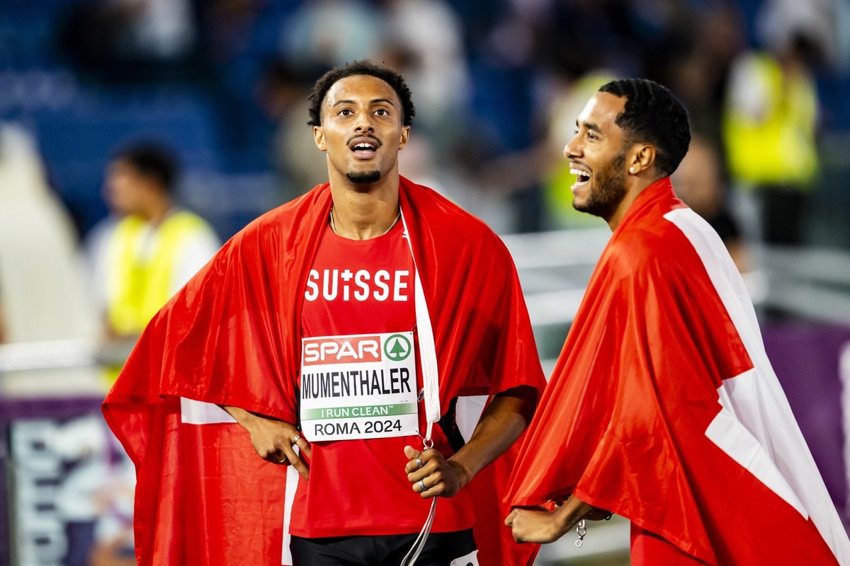 Gold medalist Timothe Mumenthaler of Switzerland, left, and bronze medalist William Reais of Switzerland, right, celebrate during the men's 200 meters final at the European Athletics Championship ...