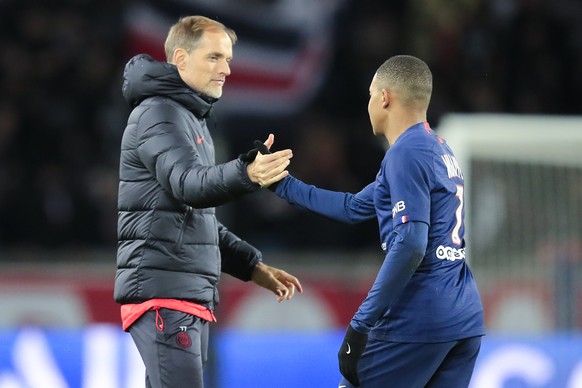 PSG coach Thomas Tuchel, left, congratulates teammate Kylian Mbappe at the end of the French League One soccer match between Paris Saint-Germain and Lille at the Parc des Princes stadium in Paris, Fri ...