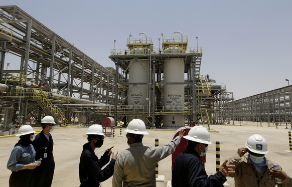 FILE - Saudi Aramco engineers and journalists look at the Hawiyah Natural Gas Liquids Recovery Plant in Hawiyah, in the Eastern Province of Saudi Arabia on June 28, 2021. Saudi oil company Aramco