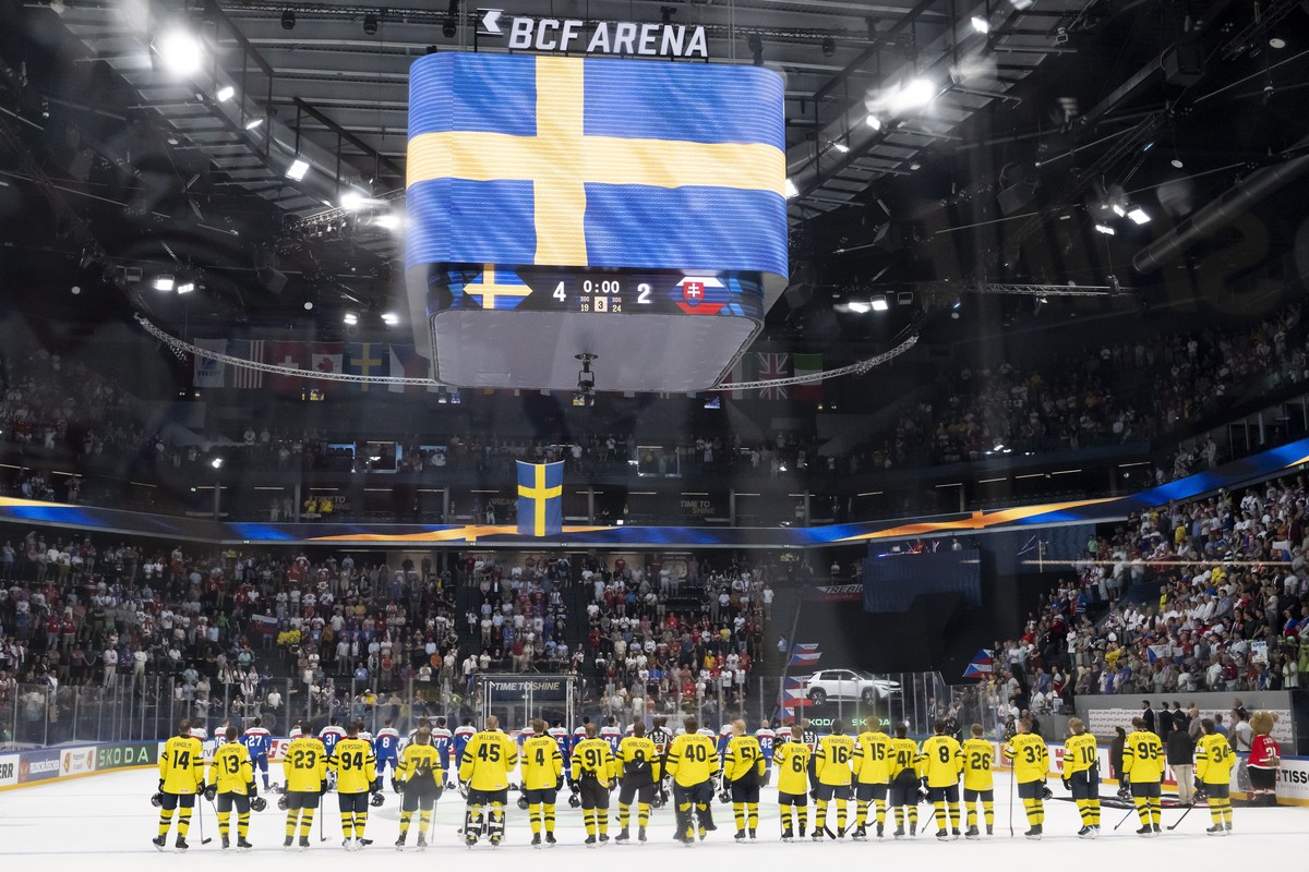 epa12995674 Sweden's players, front, and Slovakia's players, behind, listen to the Swedish national anthem after the 2026 IIHF Men's Ice Hockey World Championship preliminary round grou ...