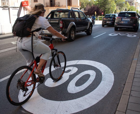 epa09191006 A bicycle runs over a 30km per hour limit sign in a street in Palma de Mallorca, Spain, 11 May 2021. A new speed limit in cities comes into force in those streets with one lane and unique  ...