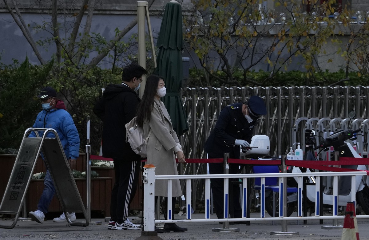 Visitors get screened by a security guard at an entrance to Peking University in Beijing, Wednesday, Nov. 16, 2022. Chinese authorities locked down the major university in Beijing on Wednesday after f ...