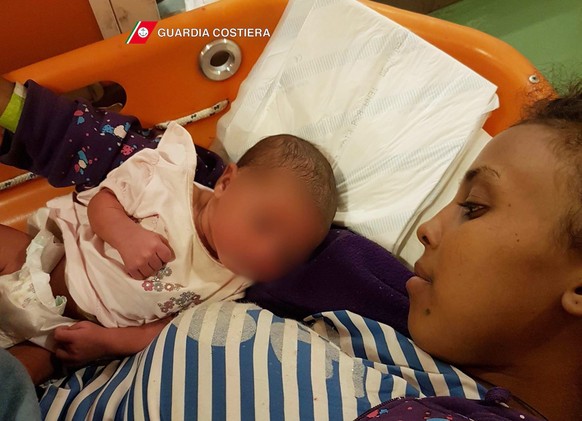 epa05570950 A handout picture provided by Guardia Costiera shows a newborn baby with his mother as they lay on a stretcher after being rescued, on the Guardia Costiera Dattilo ship in the Mediterranea ...