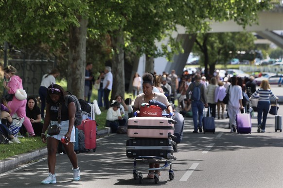 epa12060538 Commuters walk to departures at Lisbon's Humberto Delgado airport as the area is closed due to the blackout affecting Spain and Portugal, in Lisbon, Portugal, 28 April 2025. The black ...