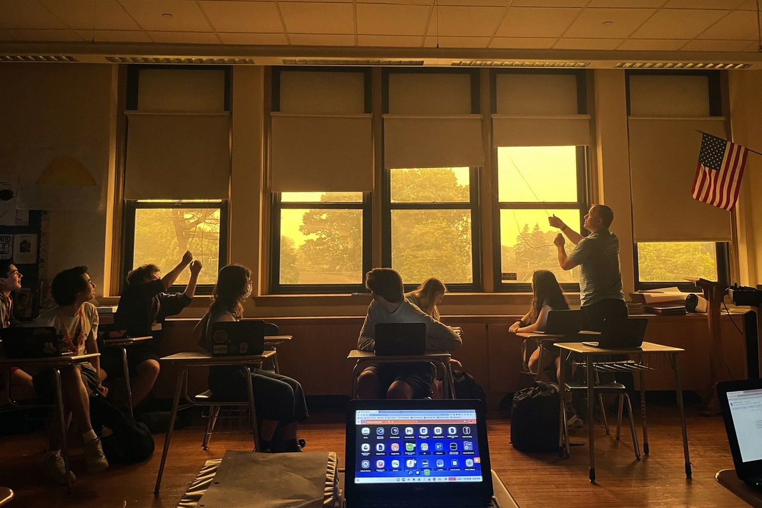 Students in a 10th grade English class at Pelham Memorial High School look outside the windows of their classroom, Wednesday, June 7, 2023, in Pelham, NY., as a yellow haze of smoke from wildfires in  ...