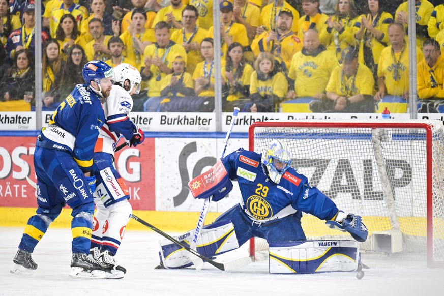 Klas Dahlbeck (HCD) Willy Riedi (ZSC), und .Torhueter Sandro Aeschlimann (HCD), von links, kaempfen um den Puck beim dritten Eishockey Playoff Halbfinalspiel der National League zwischen HC Davos (HCD ...