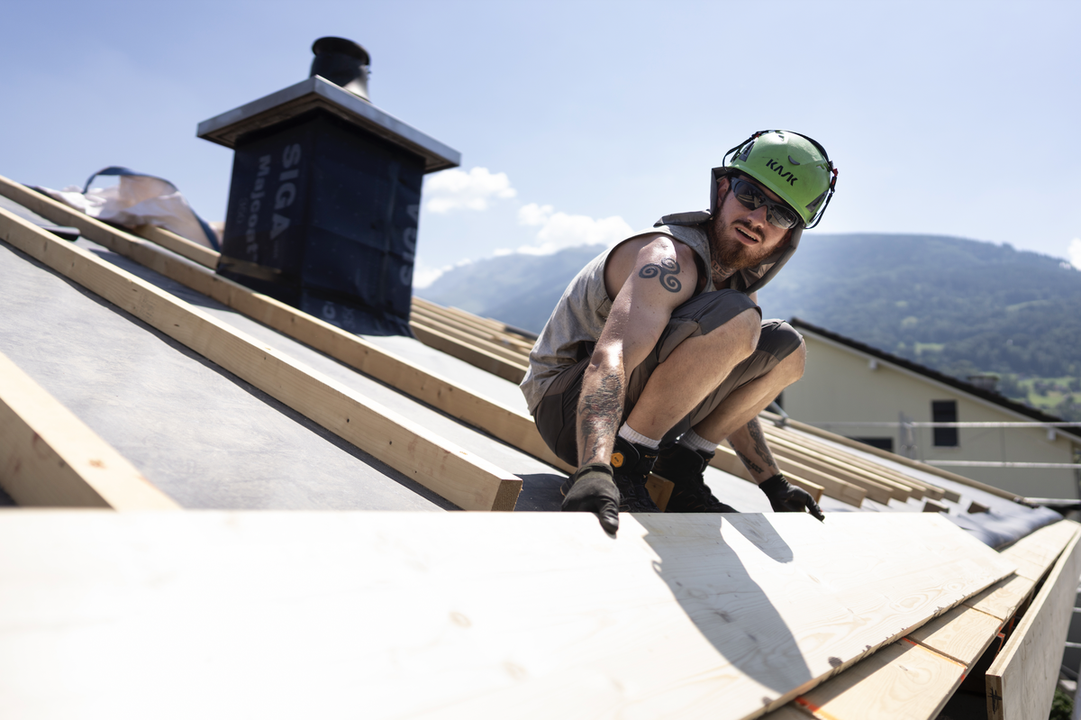 Ein Mitarbeiter der Greencover AG arbeitet an der Sanierung und Neuisolierung eines Daches bei grosser Hitze und starker Sonne, fotografiert am Mittwoch, 24. Juni 2026 in Mels (KEYSTONE/Gaetan Bally)