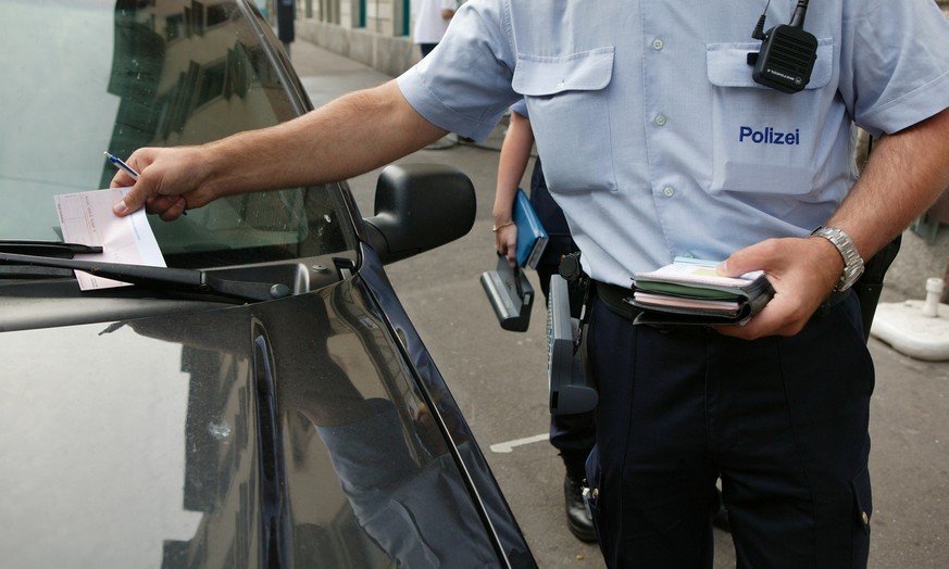 Ein Mitarbeiter des Polizeilichen Assistenzdienstes (PAD) verteilt am 4. August 2004 in Zuerich Strafzettel wegen Falschparkens. Der Polizeiliche Assistenzdienst ist eine Dienstabteilung der Zuercher  ...