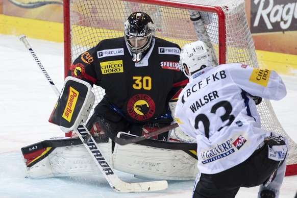 Gotterons Samuel Walser, rechts, trifft gegen Berns Torhueter Philip Wuethrich zum 2:1 im Eishockey Meisterschaftsspiel der National League zwischen dem SC Bern und dem HC Fribourg-Gotteron, am Samsta ...