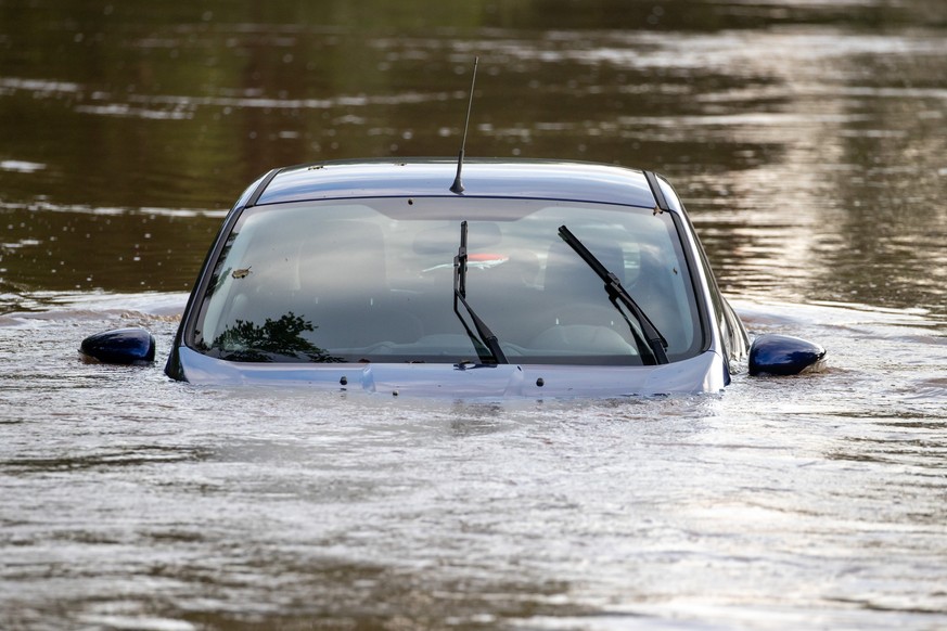 09.07.2021, Bayern, Neustadt An Der Aisch: Ein Auto steht im Hochwasser nachdem die Aisch