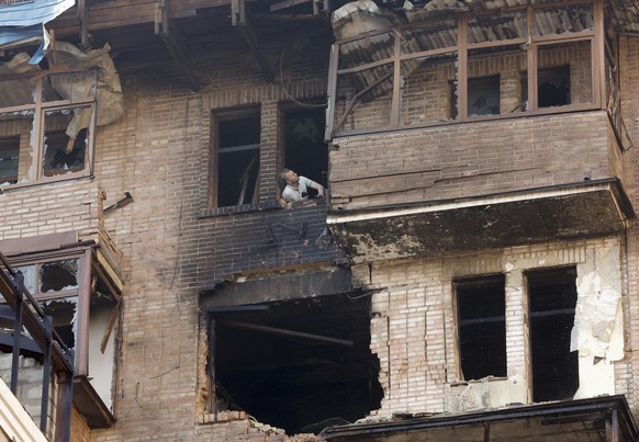 epaselect epa12228455 A man looks out of a broken window at the site of a drone strike in Kyiv, Ukraine, 10 July 2025, amid the ongoing Russian invasion. At least two people were killed in Kyiv, and m ...