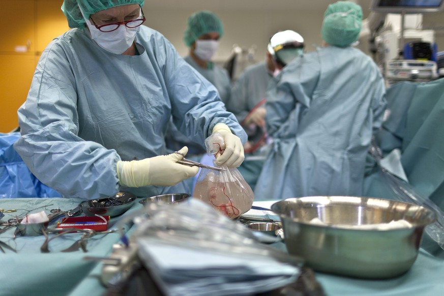 ZUR ORGANSPENDEN-DEBATTE IM STAENDERAT STELLEN WIR IHNEN FOLGENDES THEMENBILD ZUR VERFUEGUNG - Ein Arzt oeffnet im Kinderspital Zuerich einen Sack, in dem sich ein gesundes Herz befindet. Das Herz sol ...