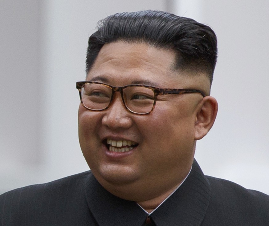 North Korean leader Kim Jong Un smiles while walking with U.S. President Donald Trump on Sentosa Island in Singapore Tuesday, June 12, 2018. Kim has a sweptback hairstyle with the sides and back shave ...