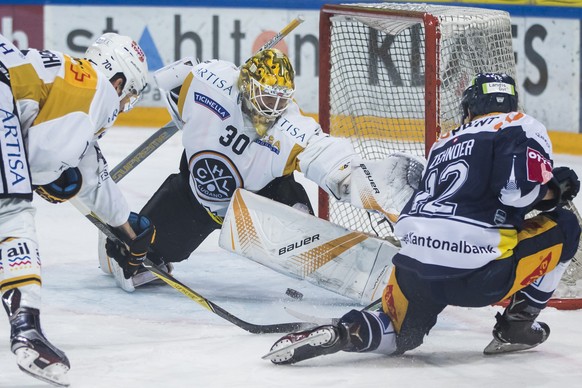 Zugs Yannick Zehnder, rechts, im Spiel gegen Luganos Goalie Elvis Merzlikins, waehrend dem Eishockey-Meisterschaftsspiel der National League zwischen dem EV Zug und dem HC Lugano, am Samstag, 9. Dezem ...