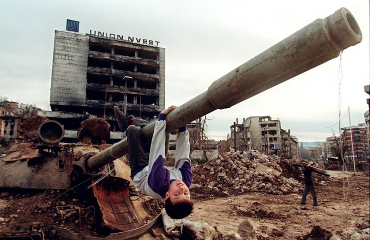 Young Bosnian boy plays on the turret of a ruined tank following the Siege of Sarajevo. Behind him, war-torn Grbavica neighbourhood. Sarajevo, 1995
bild: reddit