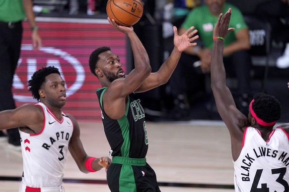 Boston Celtics&#039; Kemba Walker, center, shoots against Toronto Raptors&#039; OG Anunoby (3) and Pascal Siakam (43) during the second half of an NBA conference semifinal playoff basketball game Frid ...