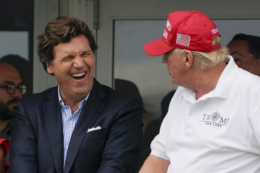 FILE - Tucker Carlson, left, and former President Donald Trump, right, react during the final round of the Bedminster Invitational LIV Golf tournament in Bedminster, N.J., July 31, 2022. Documents in  ...