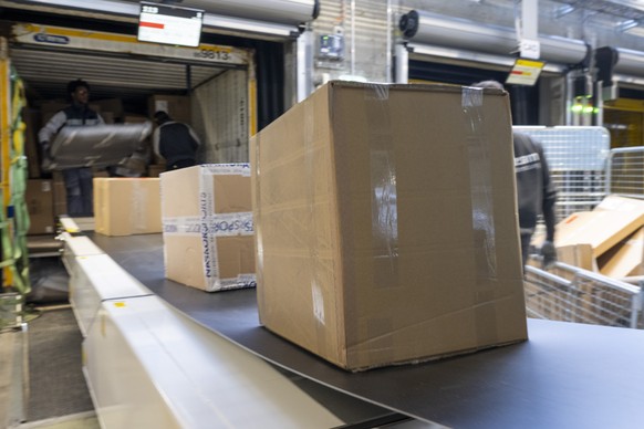 Pakete werden auf ein Foerderband gelegt im regionalen Paketzentrum der Post in Pratteln, am Donnerstag, 30. Maerz 2023. (KEYSTONE/Georgios Kefalas)