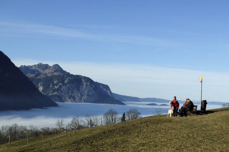 People enjoy the sun over the sea of fog with view of the Kandertal, in Aeschiried, canton of Bern, Switzerland, on Thursday, December 22, 2016. (KEYSTONE/Peter Schneider)

Personen geniessen die Sonn ...