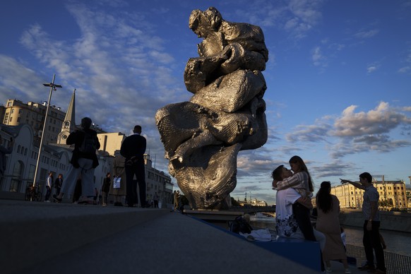 A couple share a moment next to &quot;Big Clay #4&quot; artwork by the Swiss artist Urs Fischer on Bolotnaya embankment in Moscow, Russia, Monday, Aug. 23, 2021. A 12-meter aluminum sculpture copies f ...