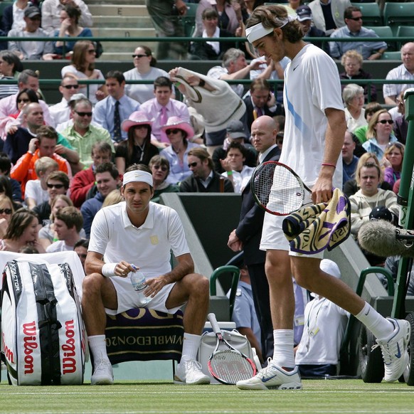 epa01050104 Juan Martin Del Potro of Argentina walks past Swiss Roger Federer (seated) during the 2nd round match against for the Wimbledon Championships at the All England Lawn Tennis Club, 28 June 2 ...