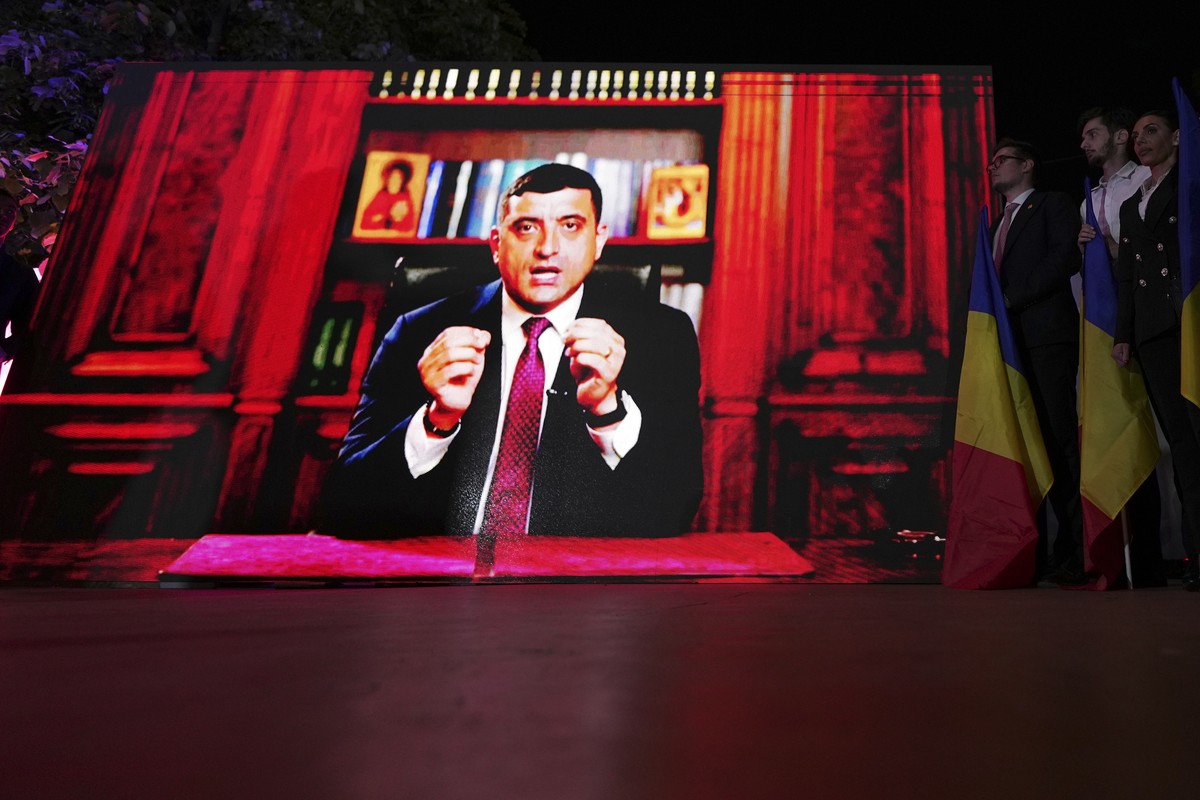 Presidential candidate George Simion is shown on a screen at the meeting of his supporters after polls closed for the first round of the country's presidential election redo in Bucharest, Romania ...