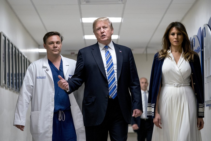 President Donald Trump, center, accompanied by first lady Melania Trump, right, and Dr. Igor Nichiporenko, left, speak to reporters while visiting with medical staff at Broward Health North in Pompano ...