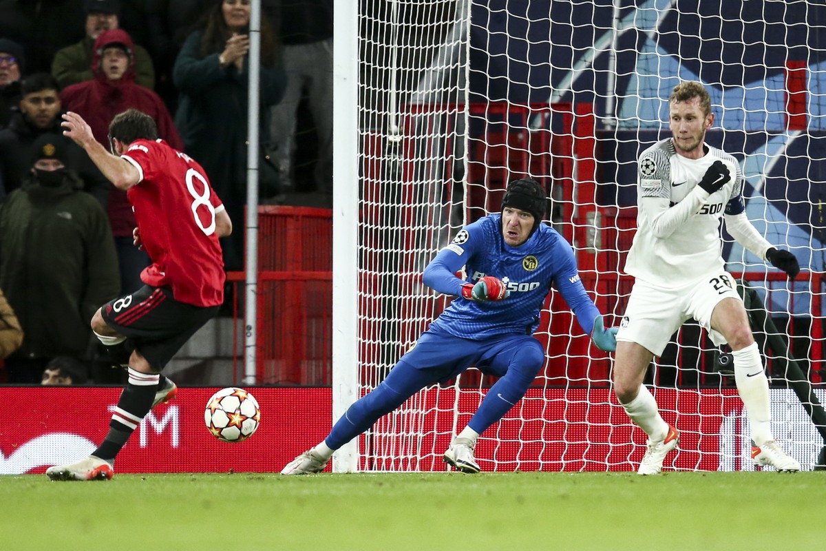 Manchester's Juan Mata, left, Young Boys' goalkeeper Guillaume Faivre, center, and Young Boys' Fabian Lustenberger, right, fight for the ball during the UEFA Champions League match betw ...
