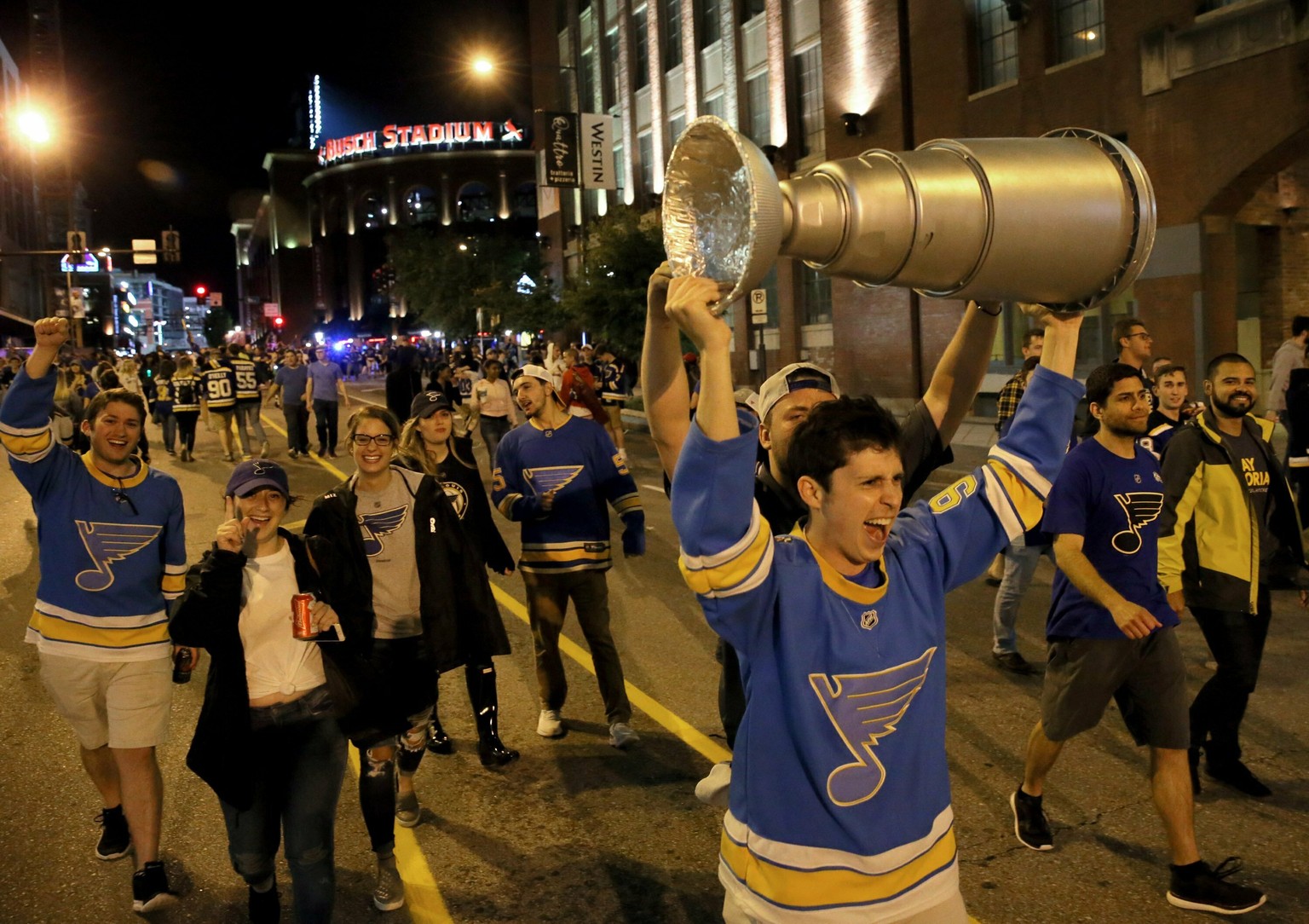 Joel Glasscock, from Belleville, Ill., marches down a St. Louis street Wednesday night, June 12, 2019, with a model of the Stanley Cup he made, after the Blues defeated the Boston Bruins in Game 7 of  ...