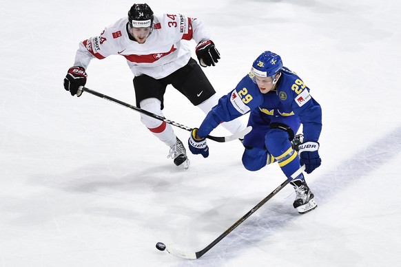 Switzerlandâs Dean Kukan, left, in action against Swedenâs William Nylander during their Ice Hockey World Championship quarter final match between Switzerland and Sweden in Paris, France on Thursd ...