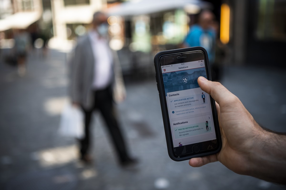 Une personne regarde sur son smartphone l'application SwissCovid, qui pourra etre telechargee des jeudi par la population suisse le mercredi 24 juin 2020 a Lausanne. (KEYSTONE/Jean-Christophe Bot ...