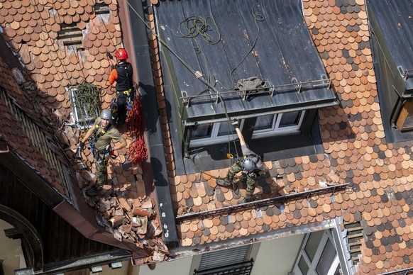 Des militaires de l&#039;armee suisse et pompiers enleves des tuiles et securisent une toiture ou les degats sont encore visibles en ville de la Chaux-de-Fonds, lors d&#039;une visite de terrain et ap ...