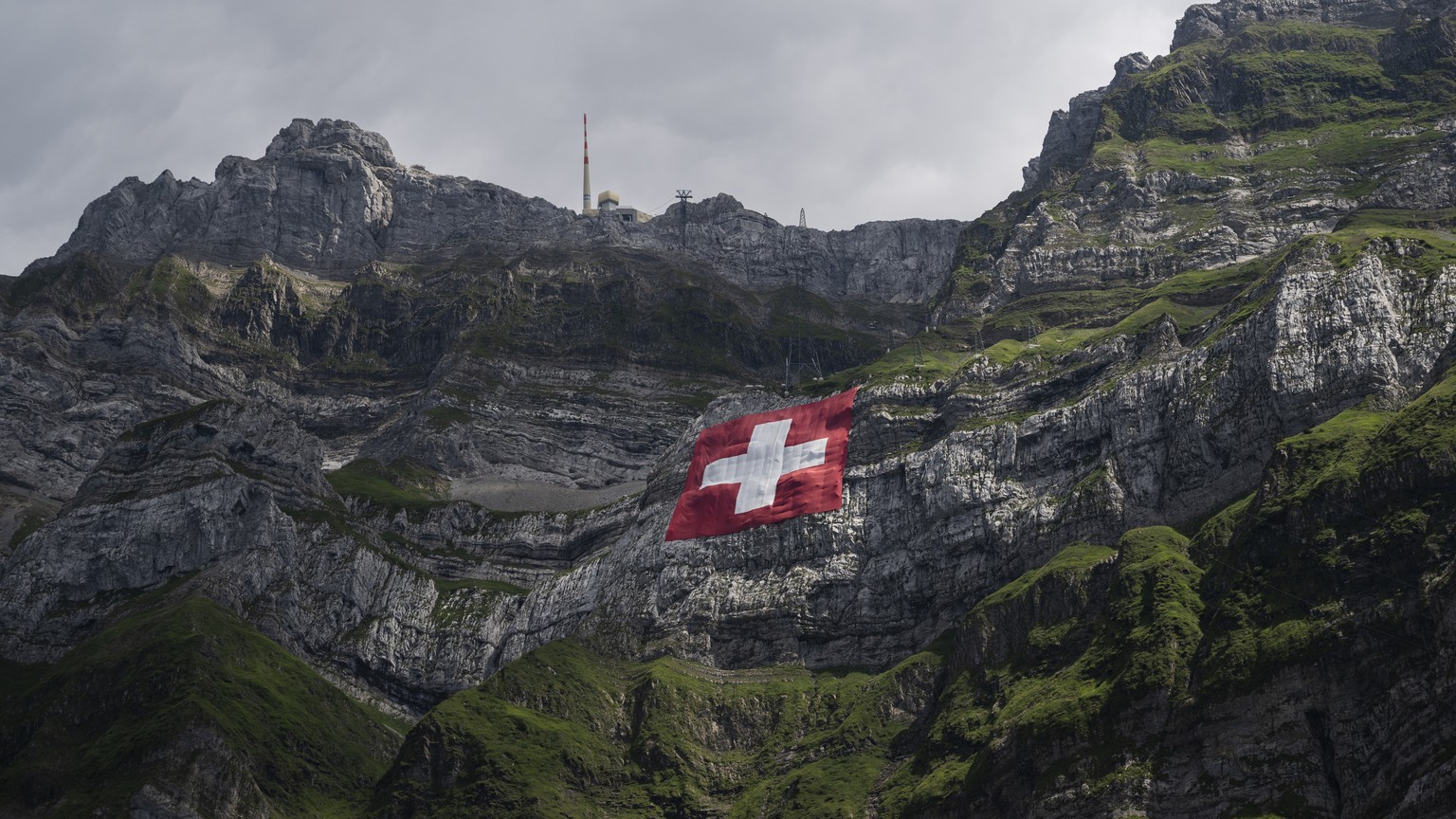Die 80x80 Meter grosse Schweizerfahne haengt an einer Felswand unterhalb des Saentis, anlaesslich des Nationalfeiertags, am Sonntag, 31. Juli 2022, auf der Schwaegalp. (KEYSTONE/Gian Ehrenzeller)